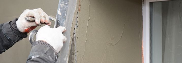 Person verputzt Fensterlaibung